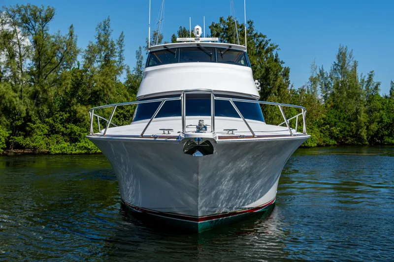 Slide: The Image of Front view of a 2008 Viking 74 Enclosed Bridge yacht on calm water. - 9