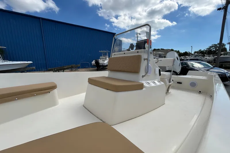 Slide: The Image of 1997 Sea Pro SV2100CC Bay Boat with tan seating, docked under a blue sky. - 13