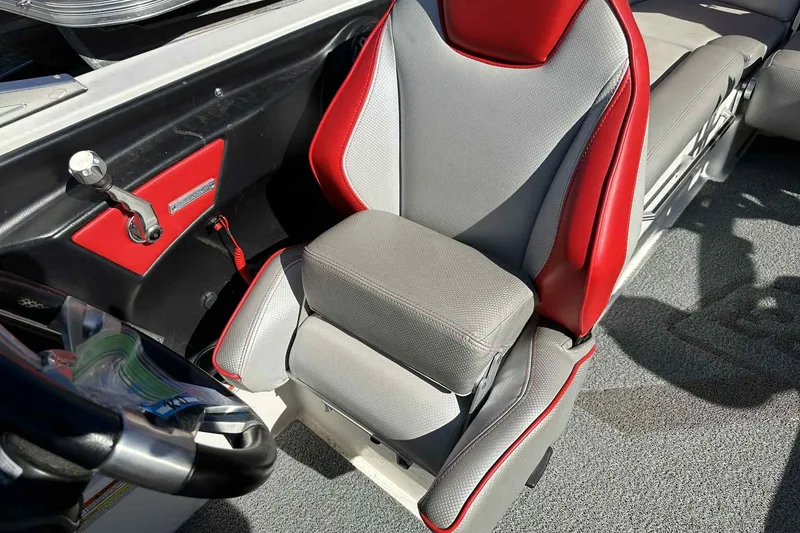 Slide: The Image of 2016 MasterCraft X23 boat interior with red and gray captain's seat. - 11
