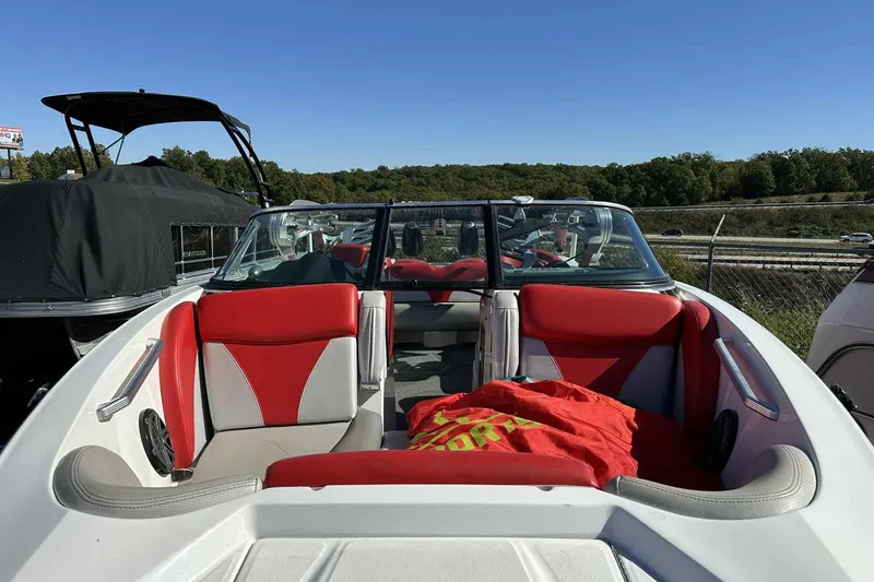 Slide: The Image of 2016 MasterCraft X23 boat with red and white interior, parked outdoors. - 15