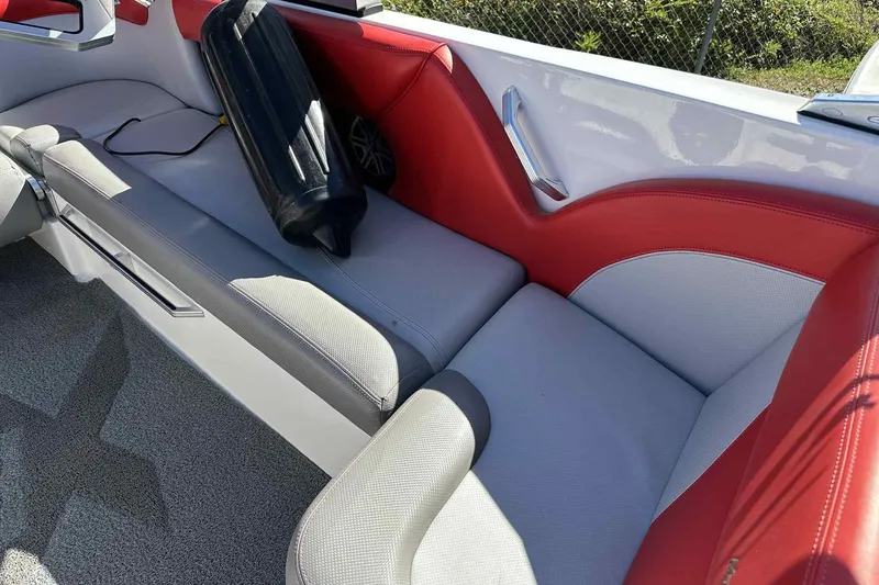 Slide: The Image of 2016 MasterCraft X23 interior with red and gray seating, featuring a black fender. - 17
