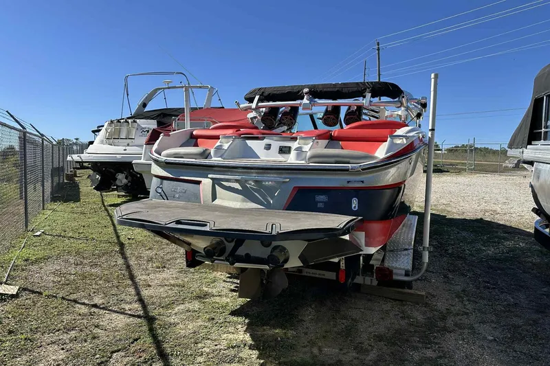 Slide: The Image of 2016 MasterCraft X23 boat in storage, rear view with red and white design. - 20