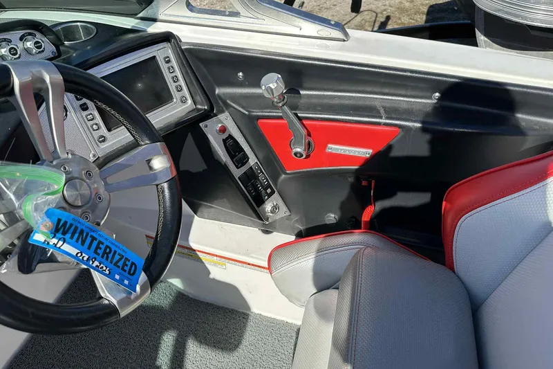 Slide: The Image of 2016 MasterCraft X23 boat interior with steering wheel and control panel. - 28