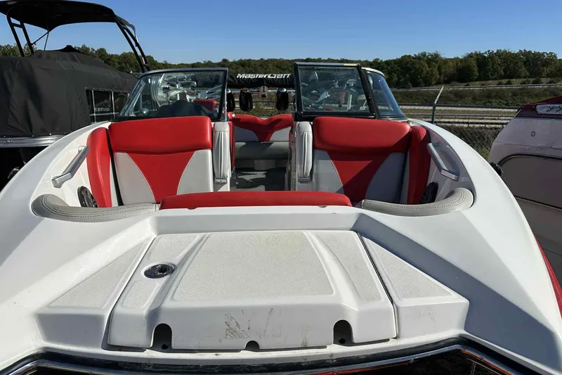 Slide: The Image of 2016 MasterCraft X23 boat with red and white interior, docked outdoors. - 4