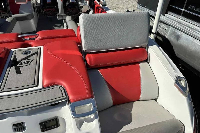 Slide: The Image of 2016 MasterCraft X23 boat interior with red and gray seating and audio system. - 6