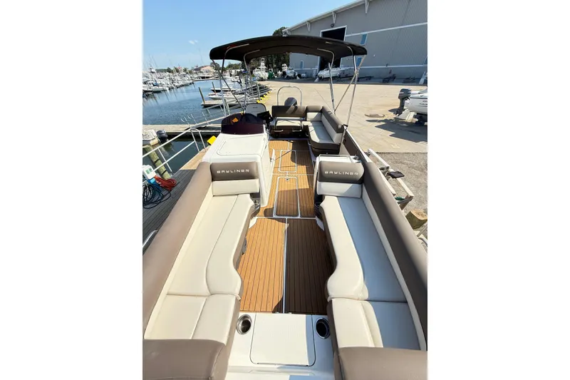 Slide: The Image of 2022 Bayliner Element XR7 boat with spacious seating and sleek design at a marina. - 14