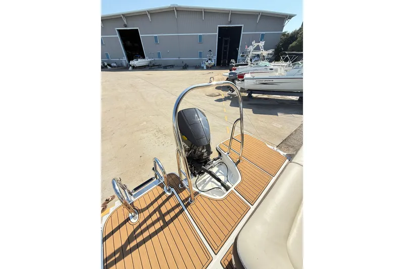 Slide: The Image of 2022 Bayliner Element XR7 boat with outboard motor and teak deck, near storage facility. - 27