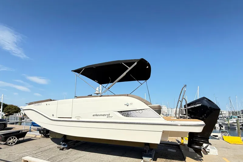 Slide: The Image of 2022 Bayliner Element XR7 boat docked at a marina under clear blue skies. - 3