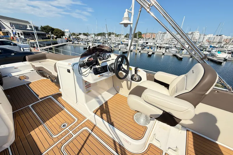 Slide: The Image of 2022 Bayliner Element XR7 boat interior with helm, seating, and marina view. - 7