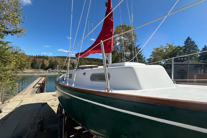 Slide: The Image of Vintage 1969 Greenwich 24 sailboat docked by a scenic lakeside. - 5