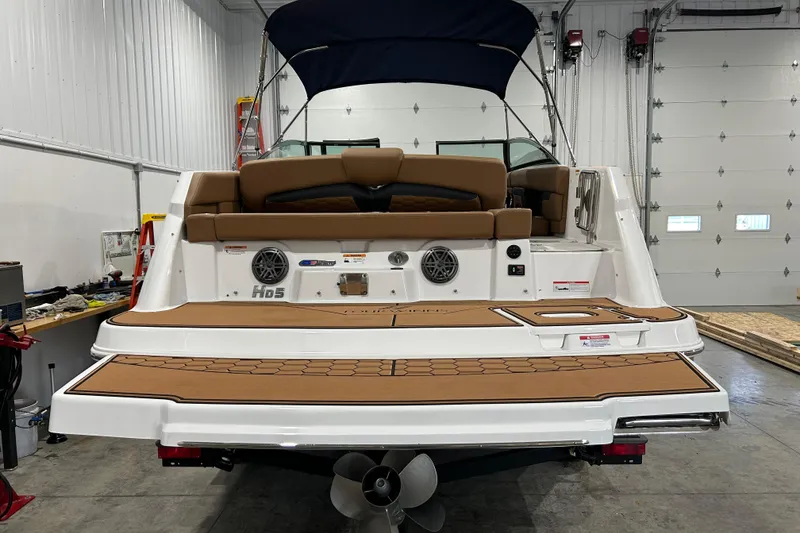 Slide: The Image of 2026 Four Winns HD5 capacity label, warning signs, and storage netting on boat interior. - 20