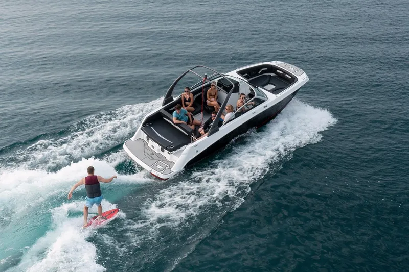 Slide: The Image of 2026 Four Winns HD5 boat on trailer, parked outside a large green building. - 3