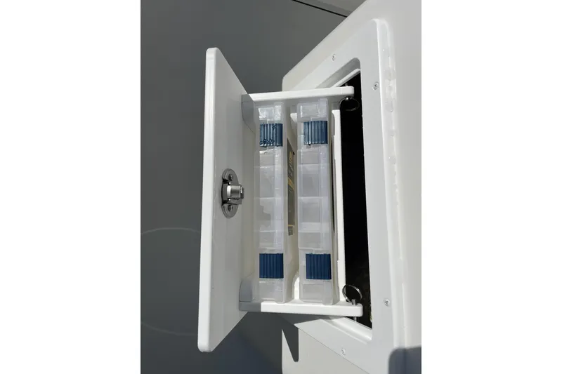 Slide: The Image of Storage compartment on 2026 Parker 230 Coastal Elite boat, featuring organized tackle boxes. - 6