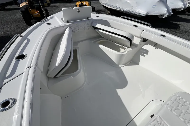 Slide: The Image of 2026 Parker 230 Coastal Elite boat interior with white seating and storage compartments. - 9