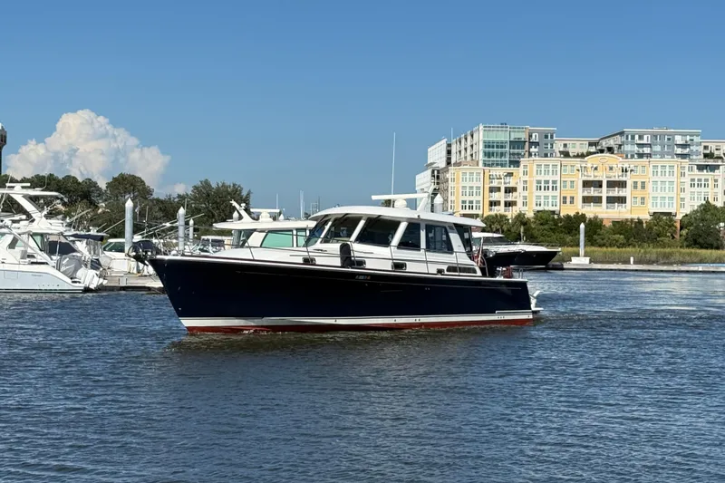 Slide: The Image of 2017 Sabre 48 Salon Express yacht cruising in a marina with buildings in the background. - 1
