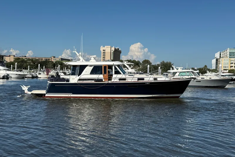 Slide: The Image of 2017 Sabre 48 Salon Express yacht docked in a marina under clear blue skies. - 11
