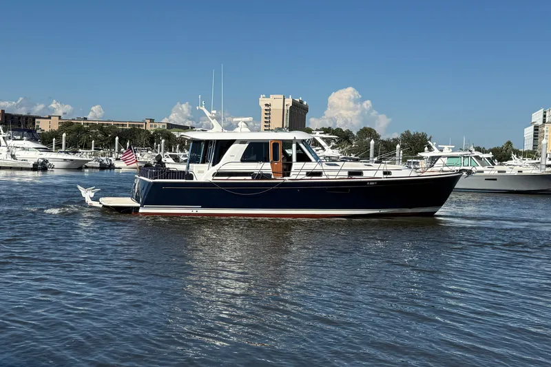 Slide: The Image of 2017 Sabre 48 Salon Express yacht cruising in a marina under a clear blue sky. - 12