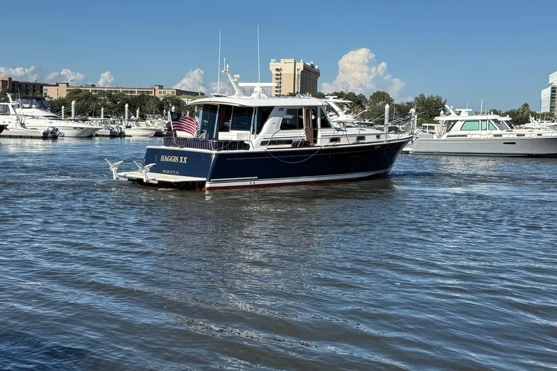 Slide: The Image of 2017 Sabre 48 Salon Express yacht on water, with marina and buildings in background. - 13