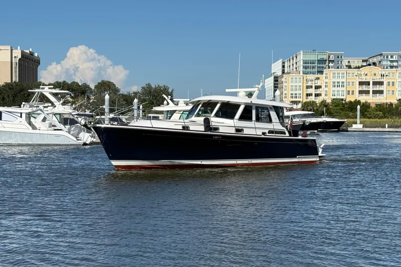 Slide: The Image of 2017 Sabre 48 Salon Express yacht cruising in a marina with buildings in the background. - 2