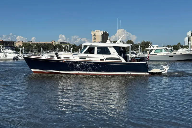 Slide: The Image of 2017 Sabre 48 Salon Express yacht cruising in a marina under clear blue skies. - 3