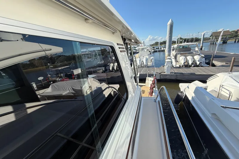 Slide: The Image of 2017 Sabre 48 Salon Express yacht docked at marina, reflecting clear blue sky. - 31
