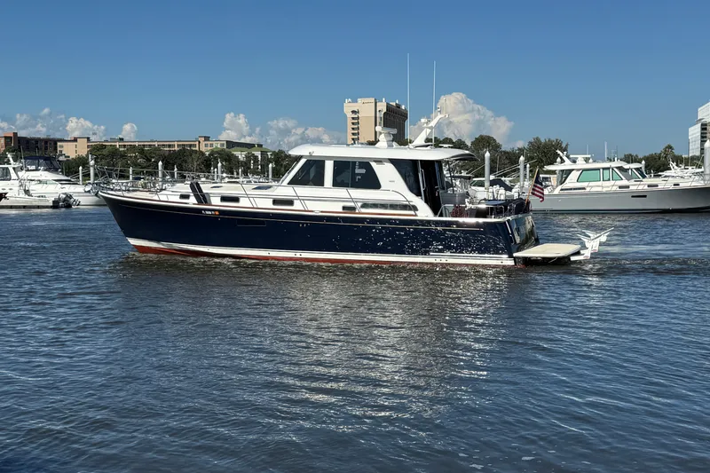 Slide: The Image of 2017 Sabre 48 Salon Express yacht cruising in a marina under a clear blue sky. - 4