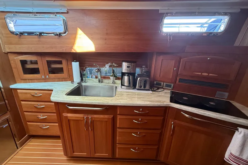 Slide: The Image of 2017 Sabre 48 Salon Express kitchen with wooden cabinetry and modern appliances. - 41