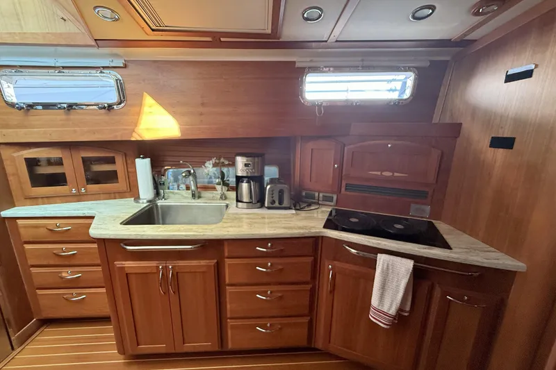 Slide: The Image of 2017 Sabre 48 Salon Express kitchen with wooden cabinetry, sink, and appliances. - 42