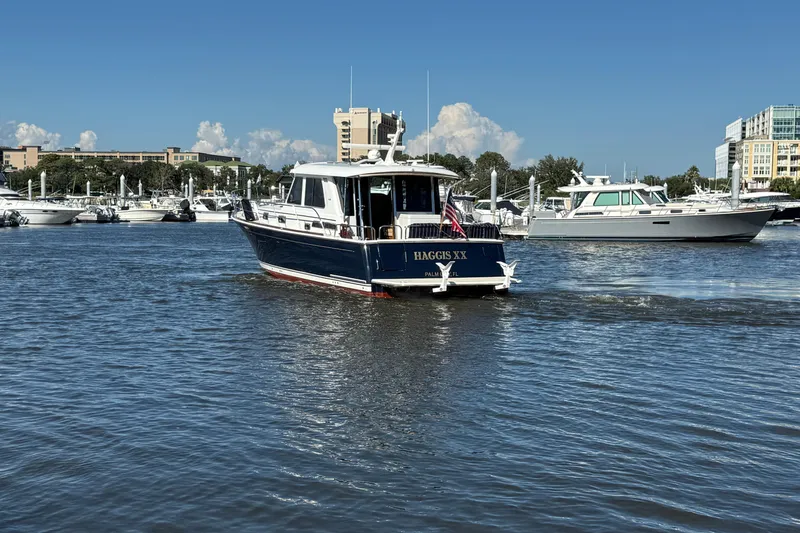 Slide: The Image of 2017 Sabre 48 Salon Express yacht cruising in a marina with other boats. - 7