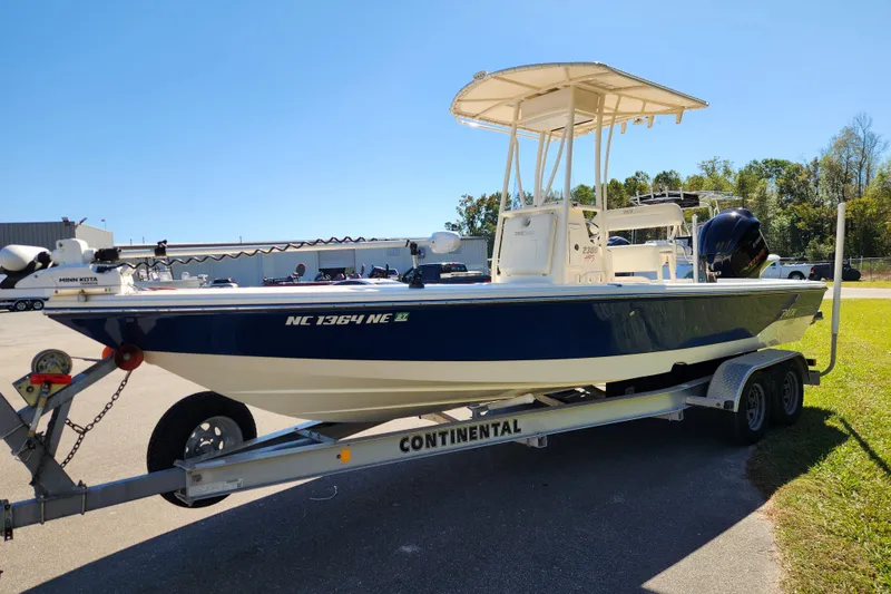 Slide: The Image of 2015 Pathfinder 2300 HPS boat on trailer, parked outdoors under clear sky. - 7