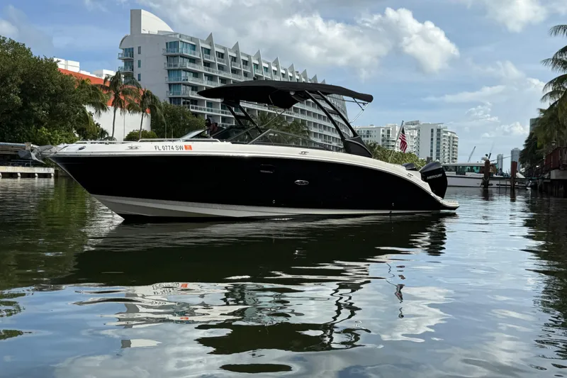 The Image of 2021 Sea Ray SDX 290 Outboard boat on calm water, urban skyline background. - 0