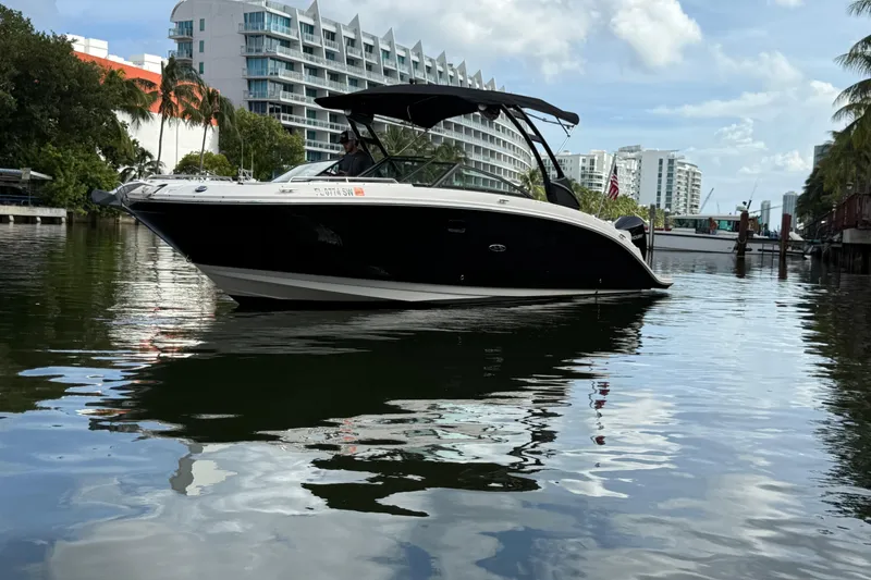 Slide: The Image of 2021 Sea Ray SDX 290 Outboard boat on calm water, urban backdrop. - 1