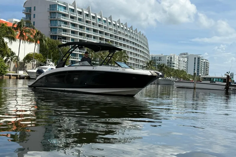 Slide: The Image of 2021 Sea Ray SDX 290 Outboard boat on water near modern buildings and palm trees. - 10