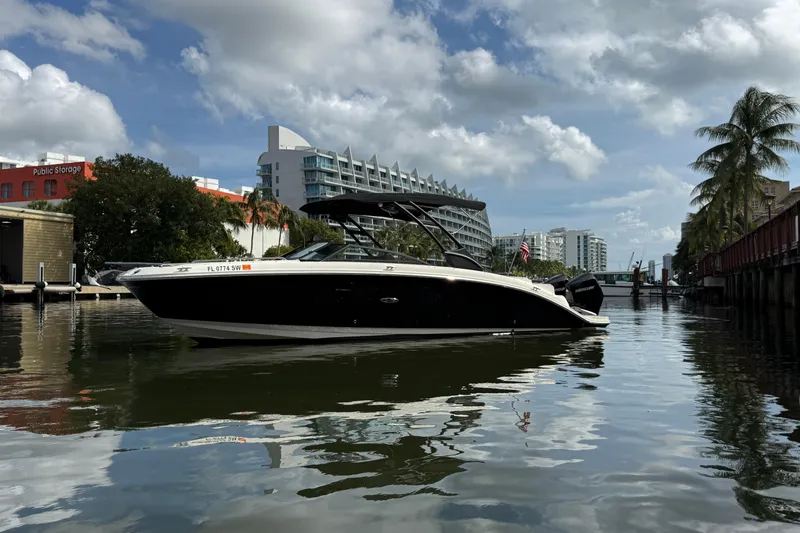 Slide: The Image of 2021 Sea Ray SDX 290 Outboard boat on a calm urban waterway. - 12