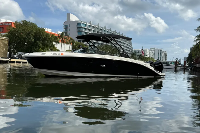 Slide: The Image of 2021 Sea Ray SDX 290 Outboard boat on a calm urban waterway. - 2