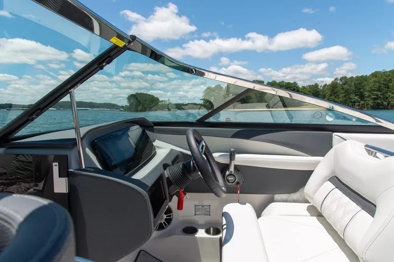 Slide: The Image of Manufacturer Provided Image: Interior of 2026 Regal LS6 Surf boat with steering wheel and dashboard, overlooking a lake. - 4