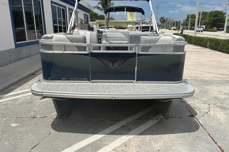Slide: The Image of 2026 Tahoe Pontoon 1780 boat parked on concrete, showcasing rear view and seating. - 4