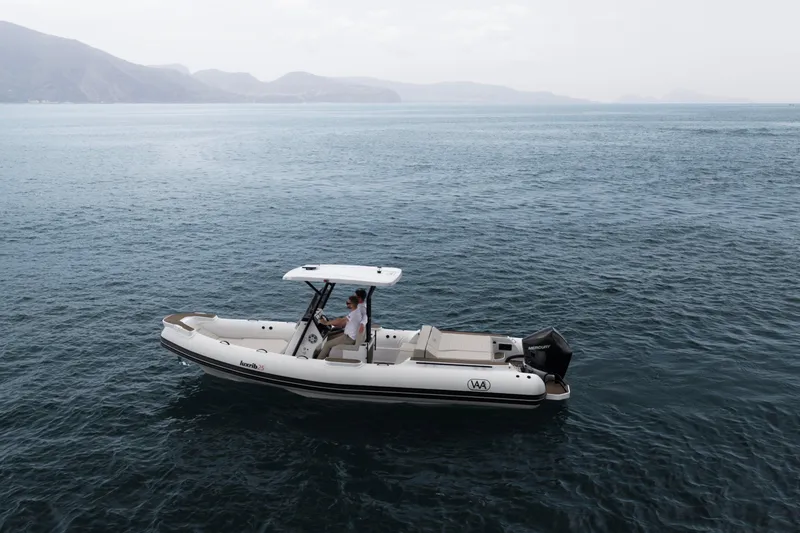 Slide: The Image of Aqvaboats Luxrib 25 (2026) cruising on serene waters with mountainous backdrop. - 26