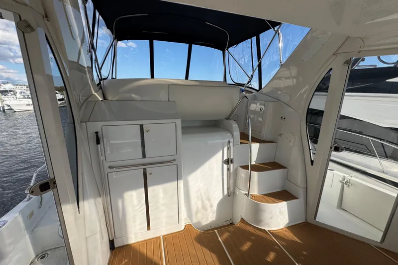 Slide: The Image of 2003 Carver 444 Cockpit Motor Yacht interior with stairs and cabinets, docked by the water. - 7