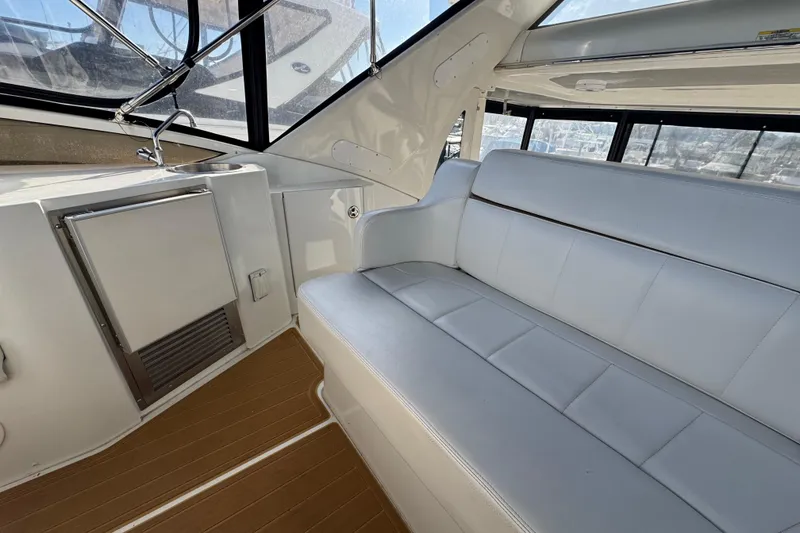 Slide: The Image of 2003 Carver 444 Cockpit Motor Yacht interior with white seating and wood flooring. - 9