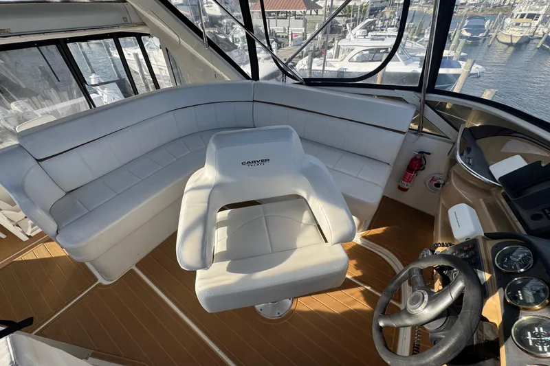 Slide: The Image of 2003 Carver 444 Cockpit Motor Yacht interior with white seating and steering wheel. - 10