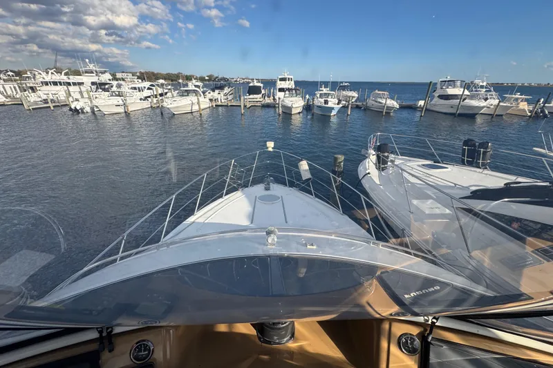 Slide: The Image of 2003 Carver 444 Cockpit Motor Yacht docked at a marina with clear blue skies. - 16