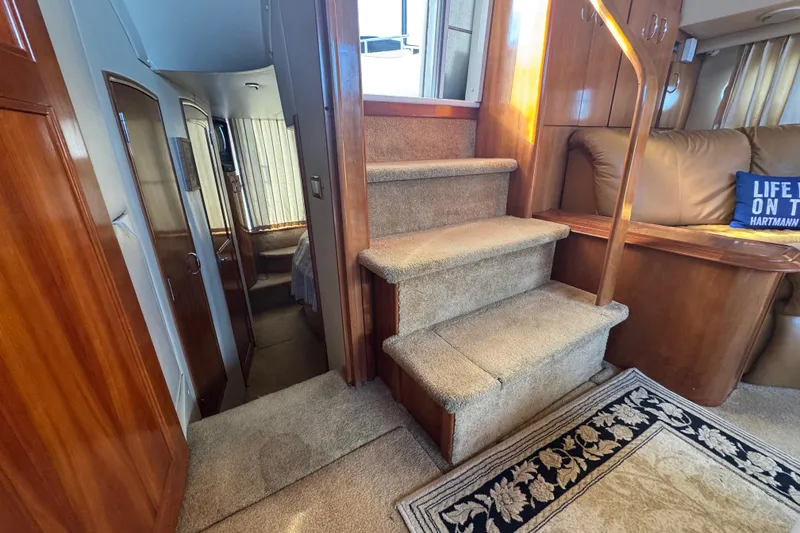 Slide: The Image of Interior of 2003 Carver 444 Cockpit Motor Yacht with carpeted stairs and wooden accents. - 18