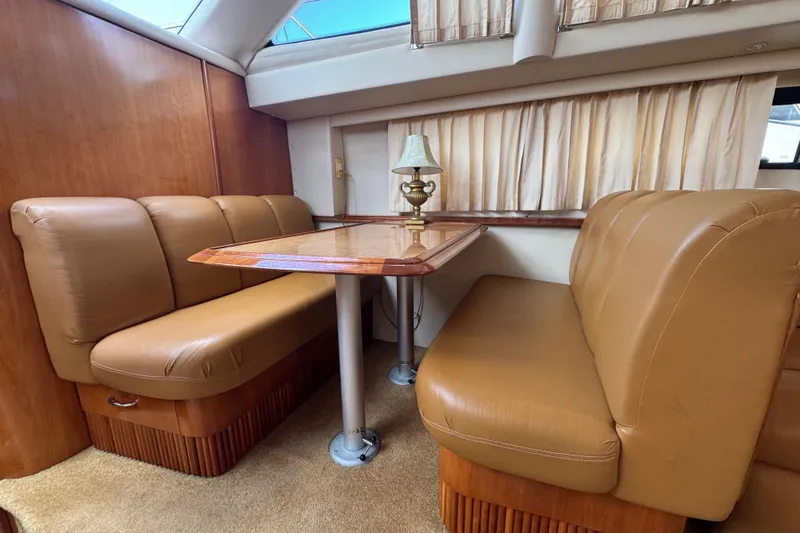 Slide: The Image of Luxurious interior of 2003 Carver 444 Cockpit Motor Yacht with leather seating and wooden table. - 21