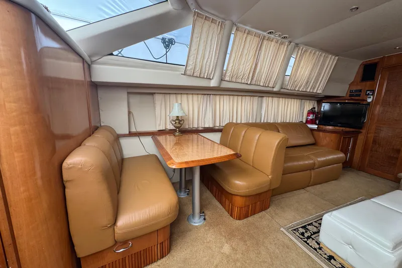 Slide: The Image of Interior of 2003 Carver 444 Cockpit Motor Yacht with leather seating and wooden table. - 27