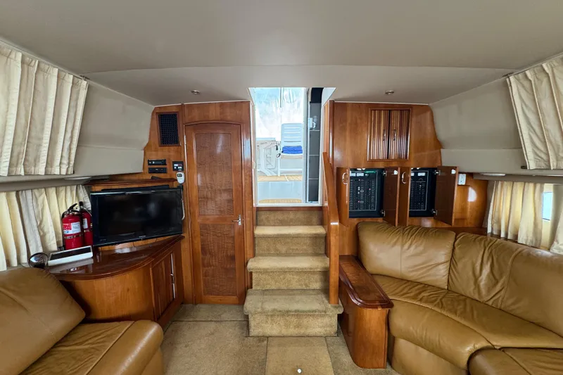 Slide: The Image of Interior of 2003 Carver 444 Cockpit Motor Yacht with leather seating and wooden cabinetry. - 29
