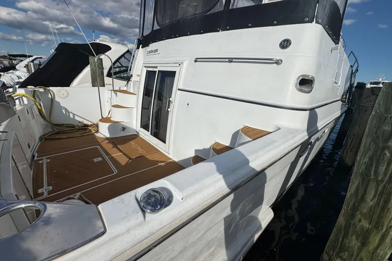 Slide: The Image of 2003 Carver 444 Cockpit Motor Yacht docked, featuring spacious deck and elegant design. - 3