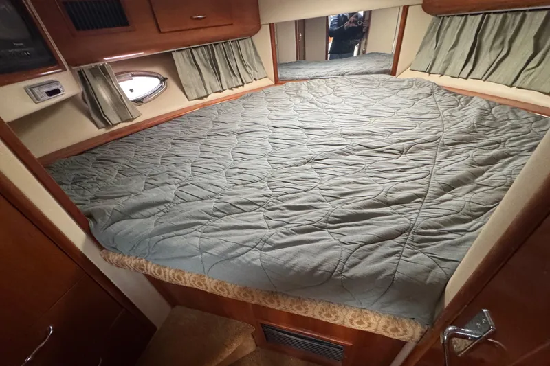 Slide: The Image of Interior cabin of 2003 Carver 444 Cockpit Motor Yacht with bed and curtains. - 34
