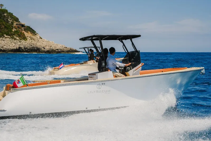 Slide: The Image of 2025 Lilybaeum Levanzo 25 Lounge Deck cruising on blue ocean near rocky coastline. - 1