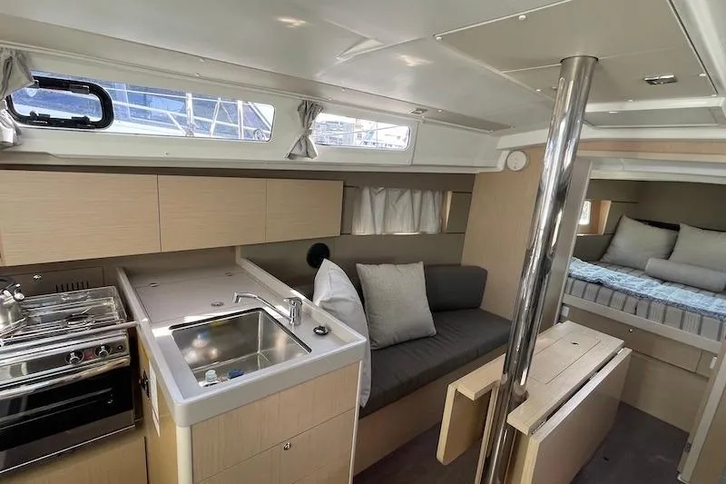 Slide: The Image of Interior of 2022 Beneteau Oceanis 35.1 yacht with modern kitchen and cozy seating area. - 5